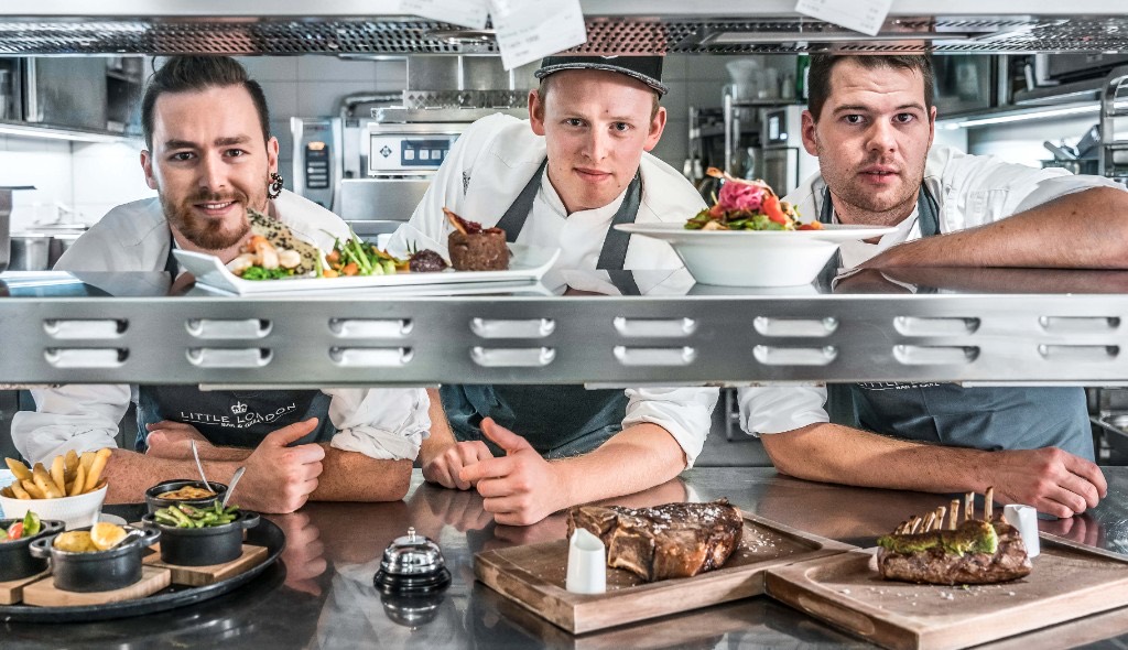 Küchenteam mit frisch angerichteten Gerichten
