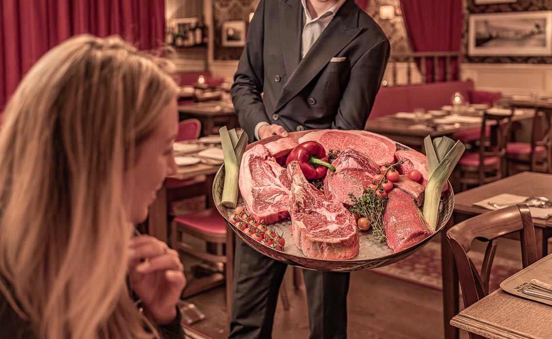 Fleischplatte wird am Tisch präsentiert