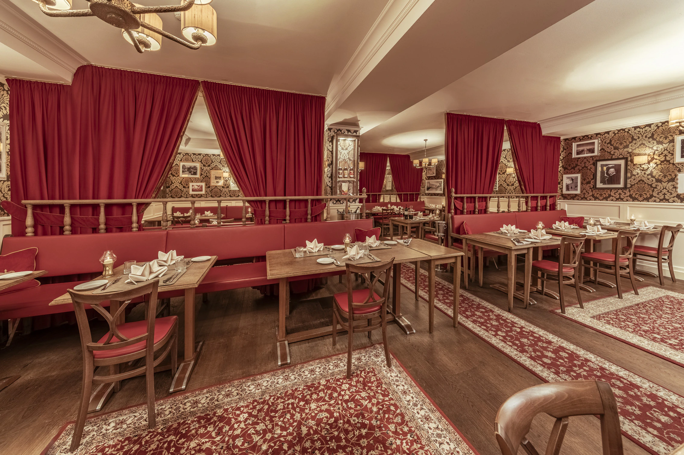 Restaurant — gedeckte Tische vor den roten Vorhängen